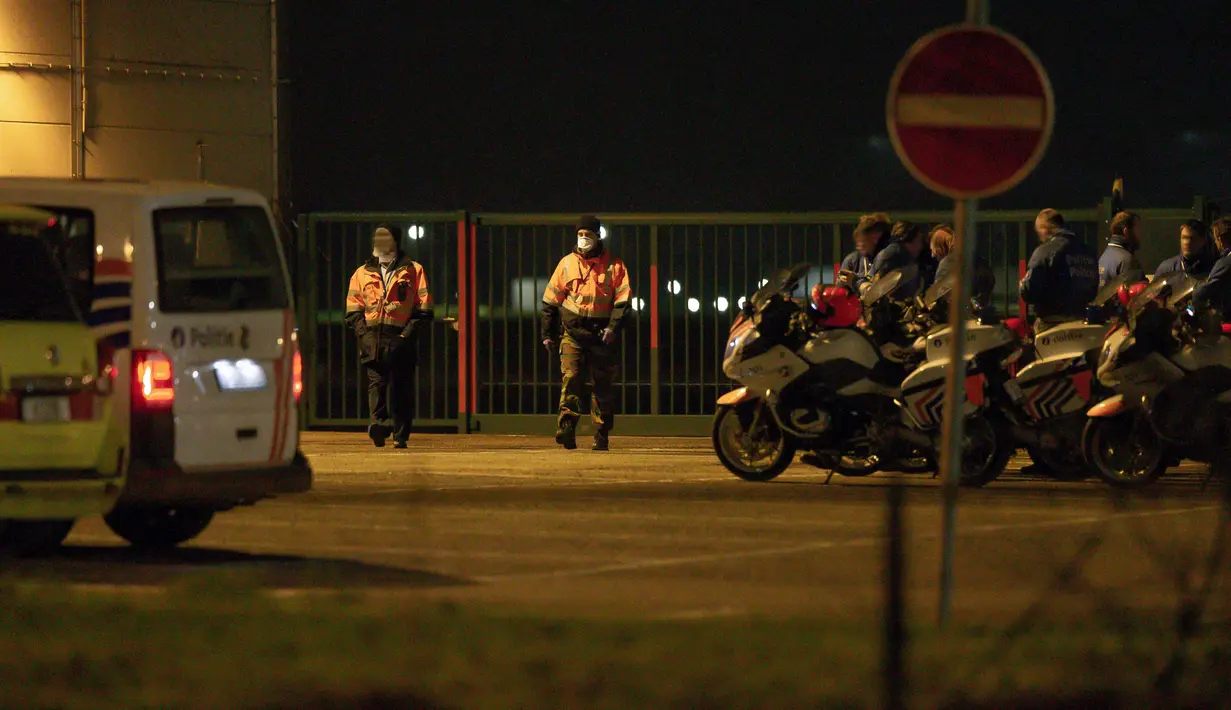 Petugas kemanan berjaga saat pesawat yang membawa penumpang dari Wuhan tiba di bandara militer di Melsbroek, Belgia, Minggu (2/2/2020). Belgia memulangkan warganya dari Wuhan menyusul wabah virus corona di kota tersebut. (NICOLAS MAETERLINCK/Belga/AFP)