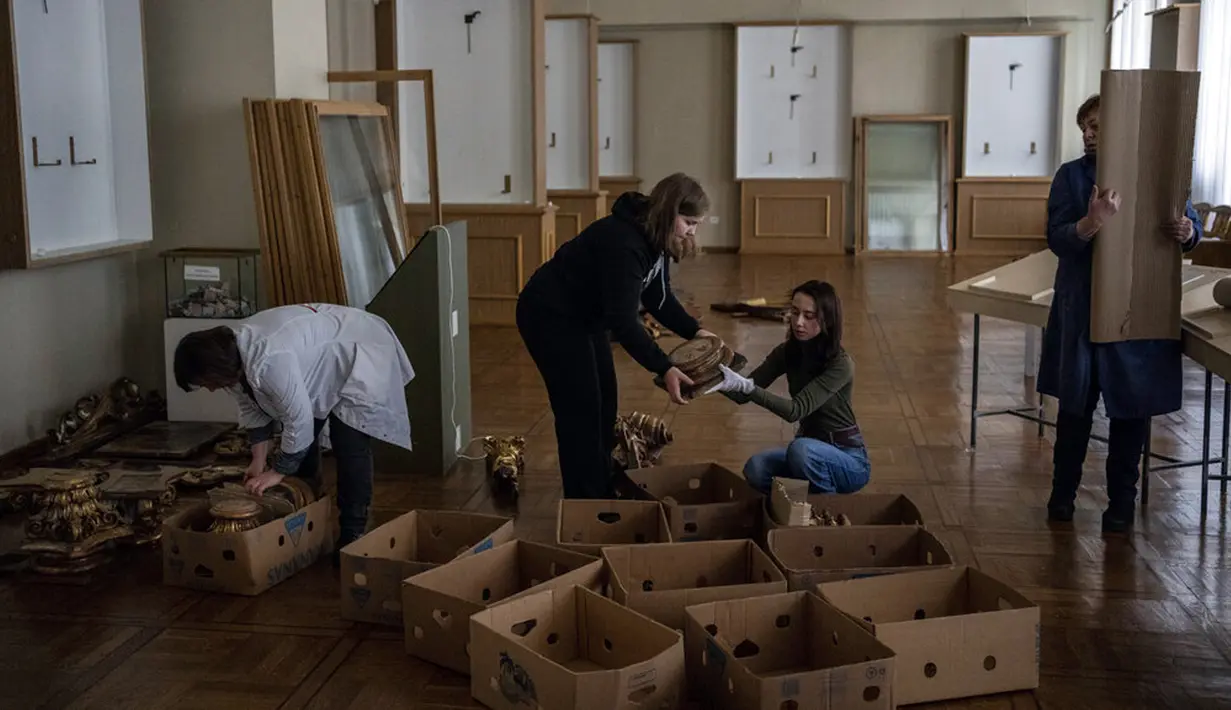Pekerja dan sukarelawan Museum Nasional Andrey Sheptytsky menyimpan potongan Barok dalam kotak kardus sebagai persiapan keselamatan jika terjadi serangan di Kota Lviv, Ukraina, 4 Maret 2022. (AP Photo/Bernat Armangue)