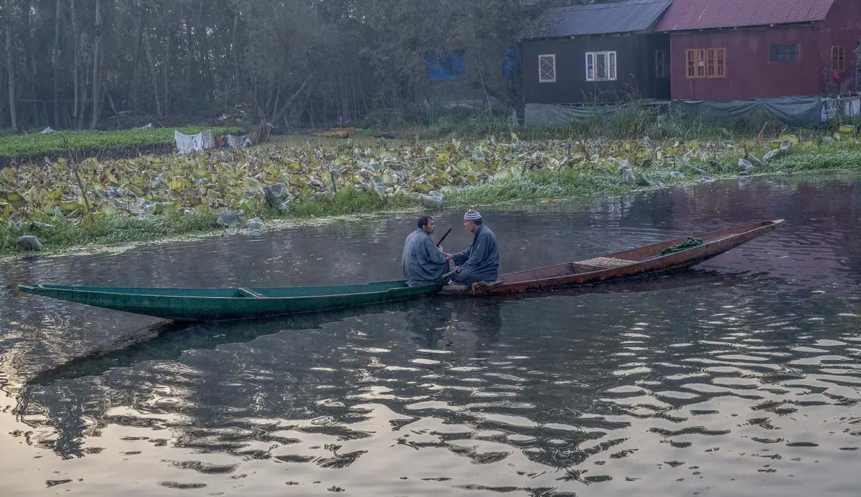 Orang-orang Kashmir mengobrol saat mereka duduk di dalam perahu mereka di Danau Dal di Srinagar, Kashmir yang dikuasai India (18/10/2020). (AP Photo/Dar Yasin)