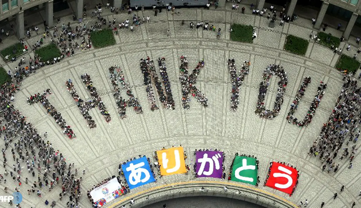 Sejumlah orang membentuk formasi untuk tulisan 'terima kasih'. Setelah Tokyo memenangkan tawaran untuk menjadi kota tuan rumah Olimpiade 2020. (AFP/JIJI PRESS/wwn)