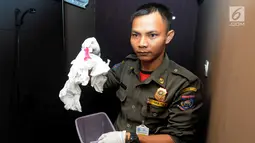 Petugas Satpol PP membawa alat kontrasepsi saat razia panti pijat di BSD, Tangerang Selatan, Selasa (25/6/2019). Dalam razia tersebut ditemukan sepasang pria dan wanita tanpa busana dalam kamar. (merdeka.com/Arie Basuki)