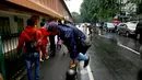Seorang pria memanjat pagar pembatas di Stasiun Cikini, Jakarta, Rabu, (20/12). Banyaknya penumpang yang mencari jalan pintas dengan melompat pagar untuk menuju akses pintu keluar menyebabkan kemacetan di kawasan stasiun. (Liputan6.com/Johan Tallo)