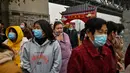 Turis domestik dari provinsi Henan yang mengenakan masker wajah mengunjungi daerah di sebelah Sungai Yangtze di Wuhan (20/11/2020). Dari total 50.340 kasus yang positif di Wuhan, 3.869 orang telah meninggal dunia akibat Covid-19 dan yang sembuh 46.471 orang. (AFP/Hector Retamal)
