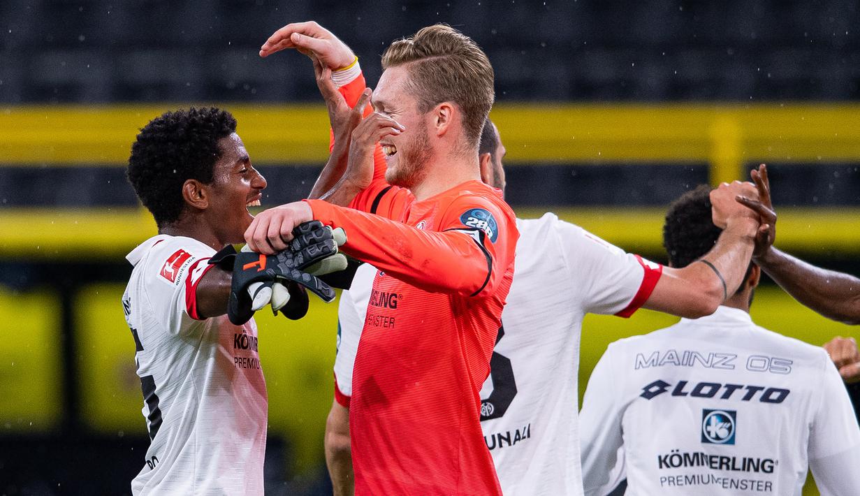 Pemain Mainz, Ridle Baku dan Florian Mueller, merayakan kemenangan atas Borussia Dortmund pada laga lanjutan Bundesliga di Signal Iduna Park, Dortmund, Kamis (18/6/2020) dini hari WIB. Borussia Dortmund menyerah 0-2 atas Mainz. (AFP/Guido Kirchner/pool)