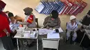 Para siswa menerima vaksin virus corona COVID-19 Sinovac di sebuah sekolah dasar di Darul Imarah, Kabupaten Aceh Besar, Provinsi Aceh, 14 Januari 2022. (CHAIDEER MAHYUDDIN/AFP)