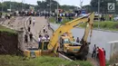 Suasana proses evakuasi mobil yang tertimbun longsor di Underpass Perimeter, Bandara Soetta, Tangerang, Banten, Selasa (6/2). Selain membersihkan longsor, alat berat juga dikerahkan untuk mengevakuasi mobil yang tertimbun. (Liputan6.com/Angga Yuniar)