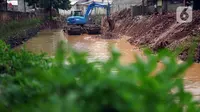 Petugas menggunakan alat berat untuk mengeruk lumpur serta memperlebar aliran Kali Krukut di kawasan Kemang, Jakarta, Selasa (10/11/2020). Pelebaran serta pengerukan tersebut bertujuan untuk memperlancar aliran air yang kerap menimbulkan banjir setiap hujan deras. (Liputan6.com/Immanuel Antonius)