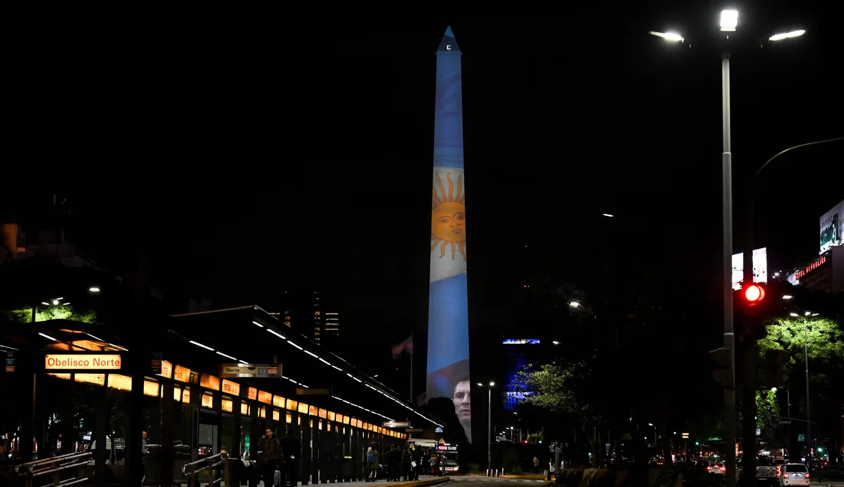 Video mapping  menunjukkan bendera nasional di Obelisk di Buenos Aires, Senin (21/11/2022). Proyeksi cahaya tersebut sebagai bentuk untuk menyemangati timnas Argentina sebelum menghadapi Arab Saudi dalam laga pertama Grup C Piala Dunia 2022, Selasa (22/11/2022) petang WIB. (Luis ROBAYO / AFP)