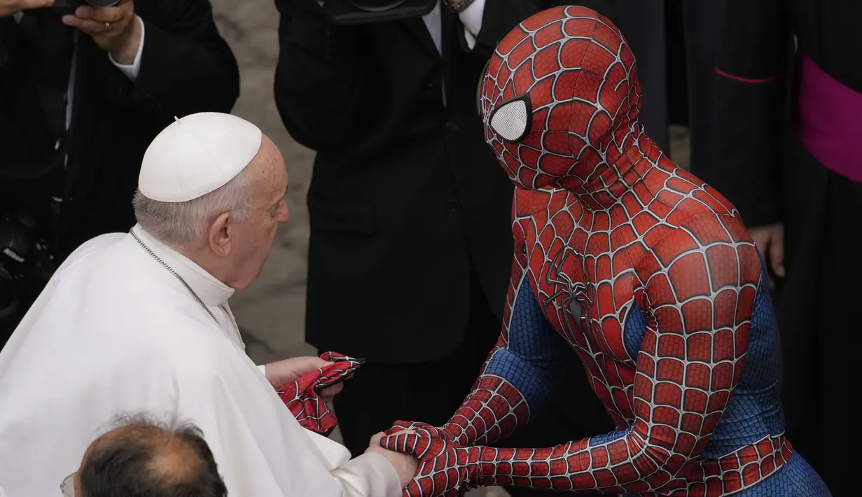 Paus Fransiskus bertemu Spider-Man, yang memberinya masker, pada akhir audiensi umum mingguan dengan jumlah umat terbatas di San Damaso Courtyard, Vatikan, Rabu (23/6/2021). Pria itu adalah Mattia Villardita (27) dari Italia utara yang menghibur anak-anak di rumah sakit. (AP Photo/Andrew Medichini)