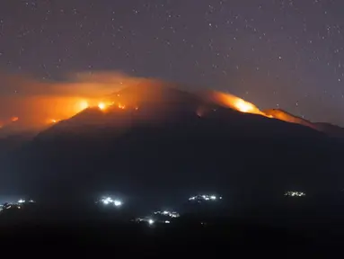 Sejumlah titik-titik api kebakaran yang melanda lereng Gunung Merbabu terlihat dari Kecamatan Magelang, Jawa Tengah, Jumat (21/8/2015). Kebakaran yang sudah terjadi sejak dua hari yang lalu itu diduga akibat musim kemarau. (AFP PHOTO/SURYO WIBOWO)