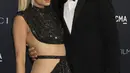 Paris Hilton dicium suaminya Carter Reum saat enghadiri LACMA ART+FILM GALA 2022 yang dipersembahkan Oleh Gucci di Los Angeles County Museum of Art di Los Angeles, California pada 5 November 2022. Mereka berpakaian apik dalam warna hitam dari ujung kepala hingga ujung kaki. (Kevin Winter/Getty Images/AFP)