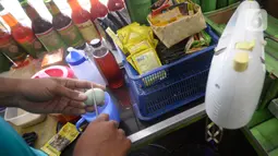 Hendri (37) menyiapkan jamu aduk untuk pembeli di kawasan Pamulang, Tangerang Selatan, Banten, Senin (28/9/2020). Menurutnya penjualan jamu aduk pada masa musim pandemi Covid 19 satu bulan ini penjualan meningkat hingga 200 persen dibandingkan bulan sebelumnya. (merdeka.com/Dwi Narwoko)