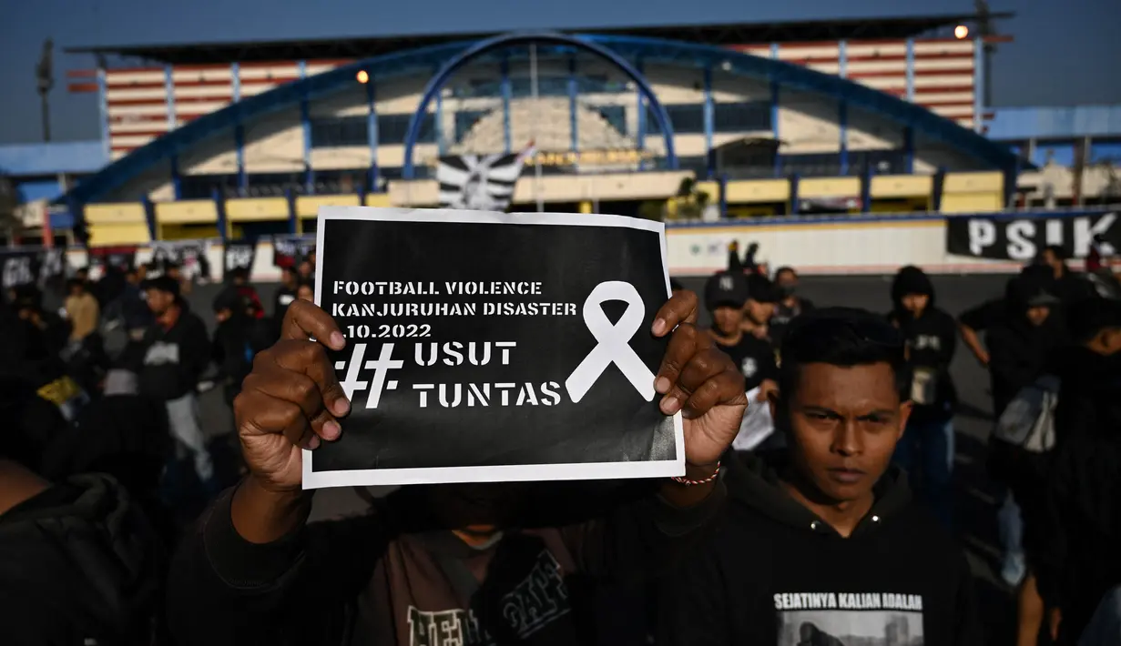 Kerabat yang berduka, para penyintas dan penggemar berkumpul untuk doa bersama di stadion Kanjuruhan Malang, Jawa Timur. (Juni Kriswanto/AFP)