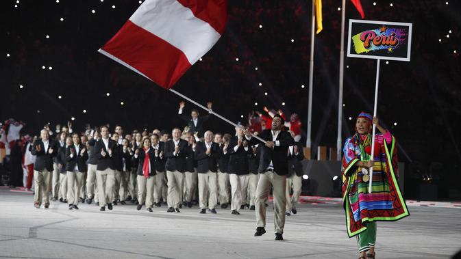 Stefano Peschiera dari Peru membawa bendera nasionalnya selama Upacara Pembukaan untuk Pan American Games 2019 di Estadio Nacional, Lima, Peru (26/7/2019). Pan American Games XVIII diadakan dari 26 Juli hingga 11 Agustus 2019. (AP Photo/Rebecca Blackwell)