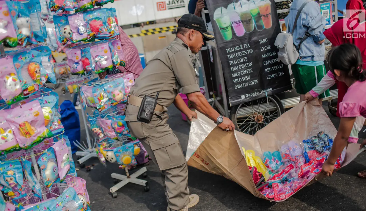 Petugas Satpol PP menertibkan PKL di kawasan car free day (CFD), Bundaran HI, Jakarta, Minggu (4/8/2019). Penertiban dilakukan karena keberadaan PKL membuat tidak nyaman pengunjung CFD yang ingin berolahraga, berorasi, atau sekadar jalan-jalan. (Liputan6.com/Faizal Fanani)