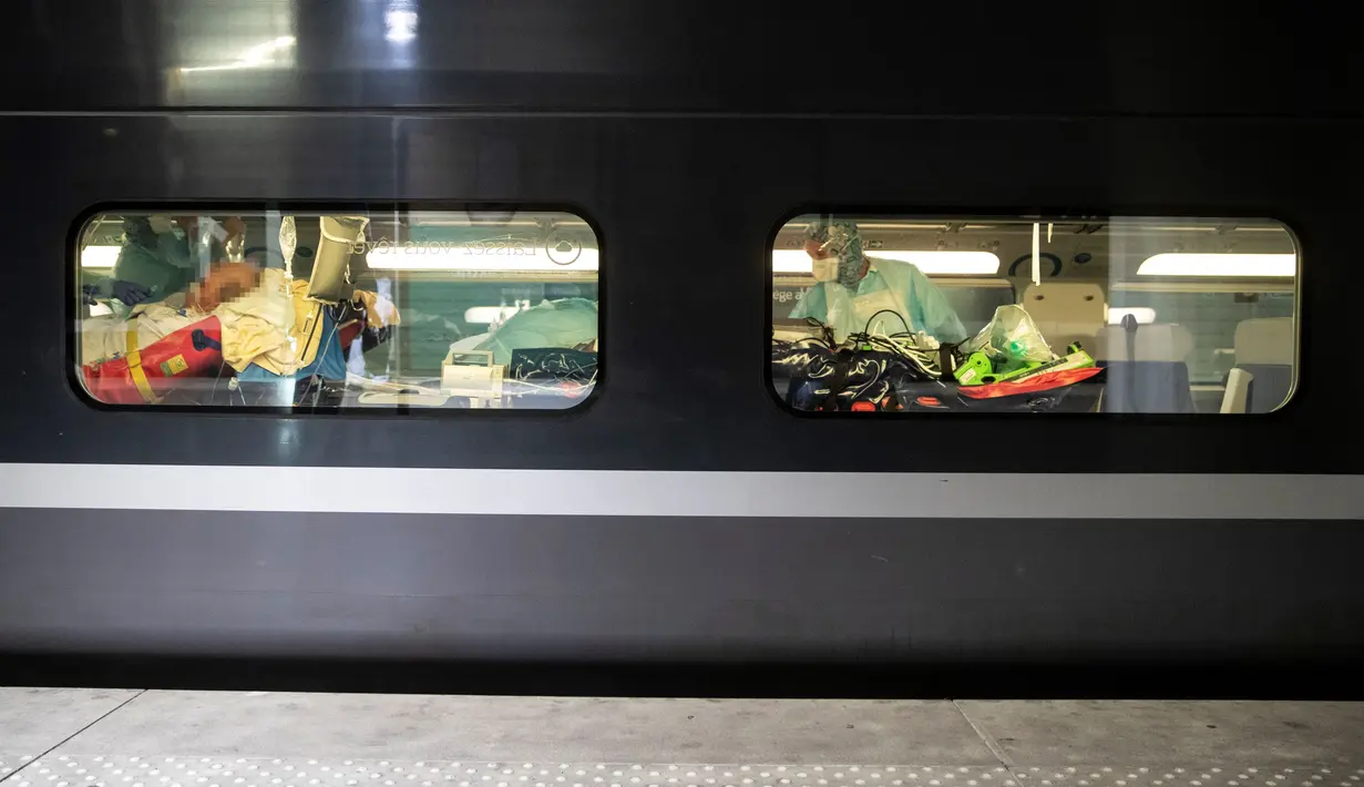 Petugas medis merawat pasien virus corona COVID-19 dalam kereta kecepatan tinggi TGV di Stasiun Gare d'Austerlitz di Paris, Prancis, Rabu (1/4/2020). Prancis mengerahkan kereta kecepatan tinggi untuk mengevakuasi pasien COVID-19 dari Paris ke wilayah Brittany. (Thomas SAMSON/AFP/POOL)