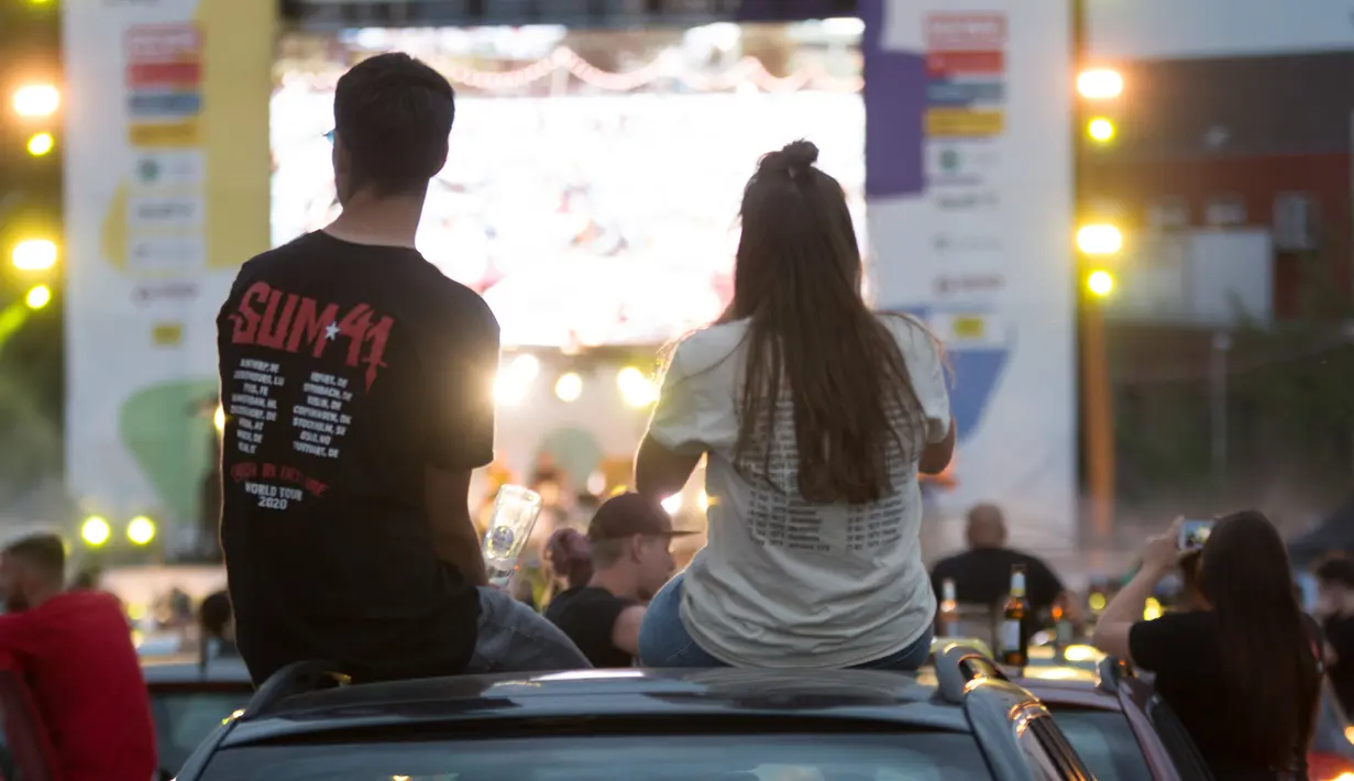 Orang-orang menonton konser drive-in dari kendaraan mereka di Bonn, Jerman, Sabtu (13/6/2020). Konser tersebut digelar dengan langkah-langkah ketat bagi para penikmat musik sambil menjaga jarak sosial. (Xinhua/Tang Ying)