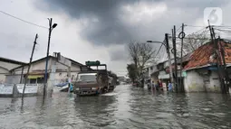 Truk menerjang banjir rob di kawasan Pelabuhan Sunda Kelapa, Jakarta, Selasa (7/12/2021). Banjir rob setinggi satu meter memutus Jalan Kerapu yang menghubungkan Ancol-Pluit. (merdeka.com/Arie Basuki)