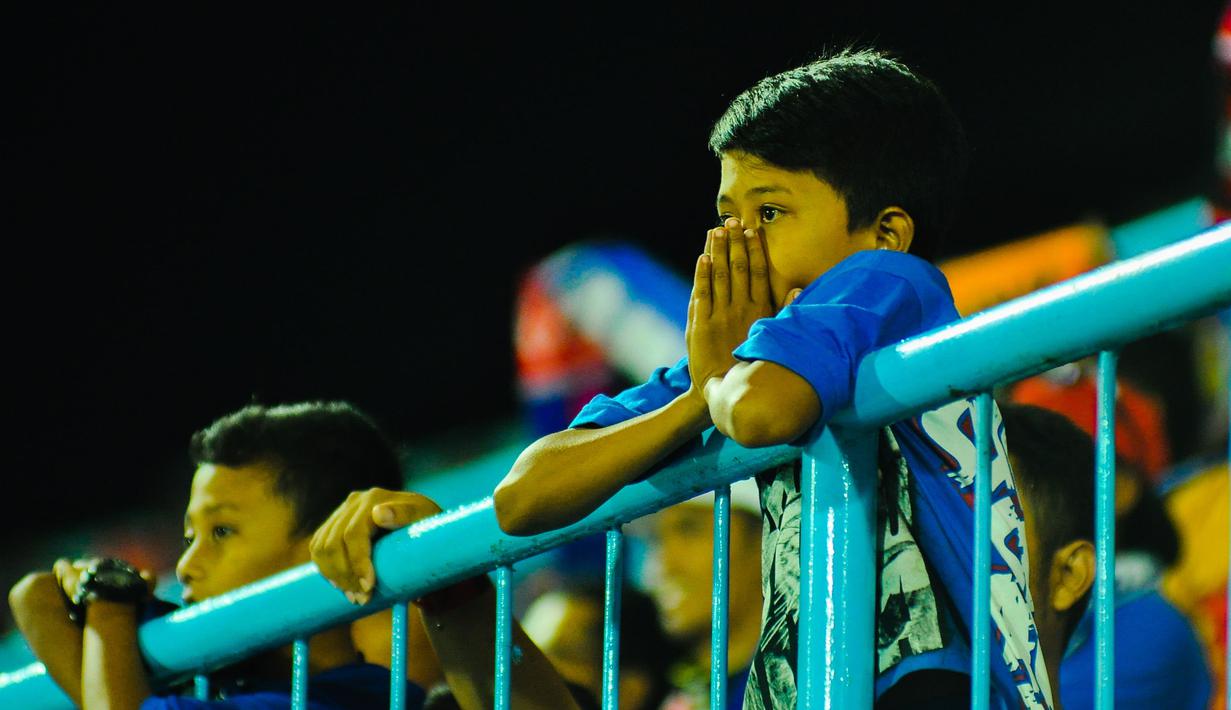 Ekspresi kesedihan Aremania setelah Arema Cronus kalah dari Mitra Kukar dalam laga semifinal Piala Jenderal Sudirman di Stadion Kanjuruhan, Malang, Minggu (17/1/2016). (Bola.com/Kevin Setiawan)