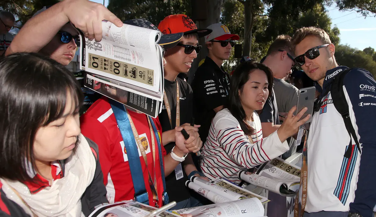 Pembalap tim Williams, Sergey Sirotkin berswafoto dengan fans sesaat sebelum latihan bebas Formula 1 (F1) GP Australia di Melbourne, Jumat (23/3). Balapan F1 GP Australia 2018 sendiri akan bergulir pada Minggu, 25 Maret besok. (AP/Rick Rycroft)
