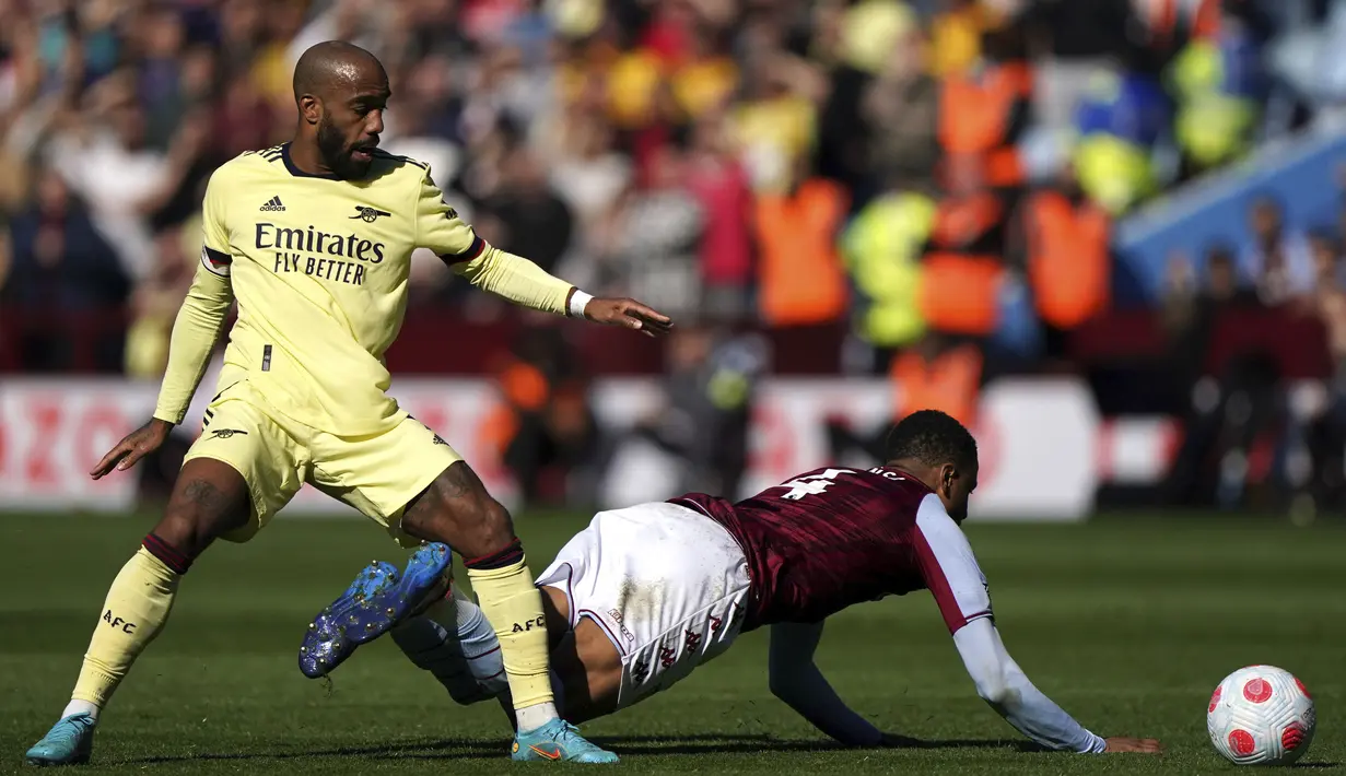 Penyerang Arsenal, Alexandre Lacazette (kiri) berebut bola dengan pemain pemain Aston Villa, Ezri Konsa pada pertandingan lanjutan Liga Inggris di Villa Park, Birmingham, Inggris, Sabtu (19/3/2022). Dengan hasil ini, Arsenal berada di peringkat keempat dengan 54 poin. (Nick Potts/PA via AP)