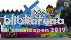 Pengemudi ojek online beristirahat di depan ornamen pintu masuk jelang pelaksanaan turnamen Indonesia Open 2019 di Istora Senayan, Jakarta, Senin (15/7/2019). Indonesia Open 2019 akan dihelat pada 16-21 Juli 2019. (Liputan6.com/Helmi Fithriansyah)
