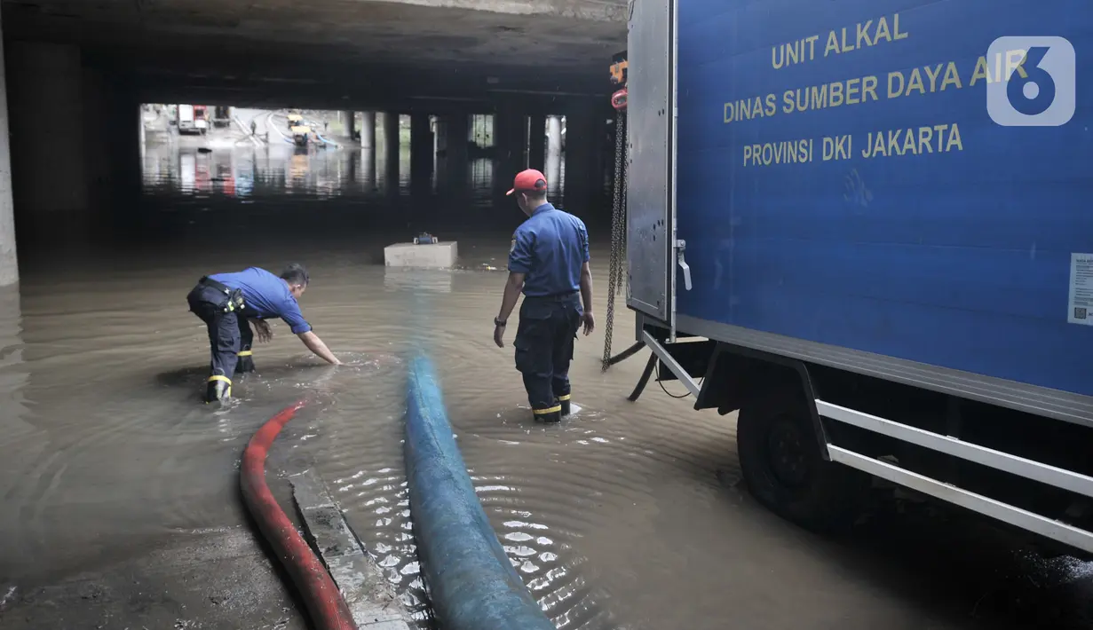 Petugas mengerahkan pompa untuk menyedot banjir di Underpass Kemayoran, Jakarta, Minggu (26/1/2020). Banjir yang terjadi sejak Jumat (24/1) lalu hingga kini belum surut. (merdeka.com/Iqbal S Nugroho)