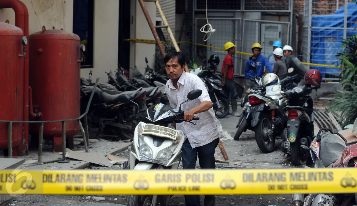 Salah satu karyawan mengevakuasi kendaraan usai tertimpa material dari pembangunan gedung Kemenhan di depan gedung Ortala Kemenkopolhukam, Jakarta, Senin (30/11/2015). Empat staff Kemenkopolhukam luka tertimpa. (Liputan6.com/HelmiFithriansyah)
