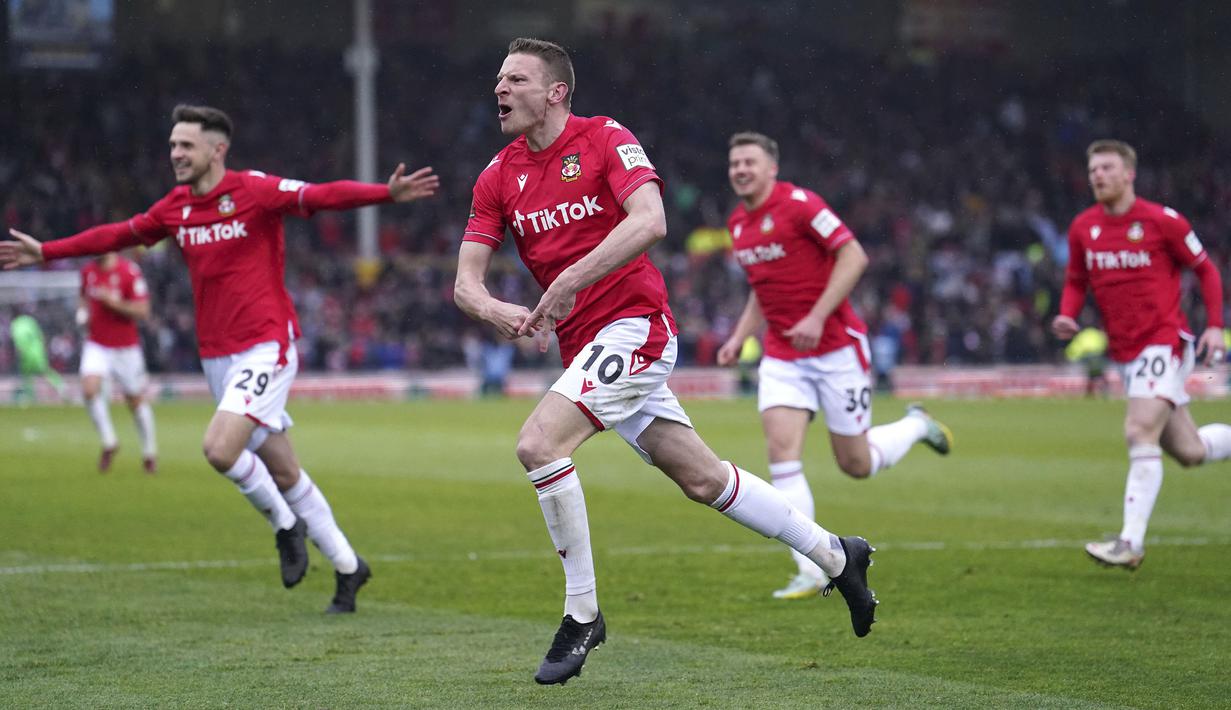 Pemain Wrexham, Paul Mullin (tengah) merayakan gol kedua tim bersama rekan-rekannya saat laga English National League antara Wrexham melawan Boreham Wood di Racecourse Ground Stadium, Wrexham, Wales, Sabtu (22/04/2023). Wrexham menang dengan skor 3-1 dan berhasil promosi ke Liga Dua Inggris. (AP/PA/Martin Rickett)