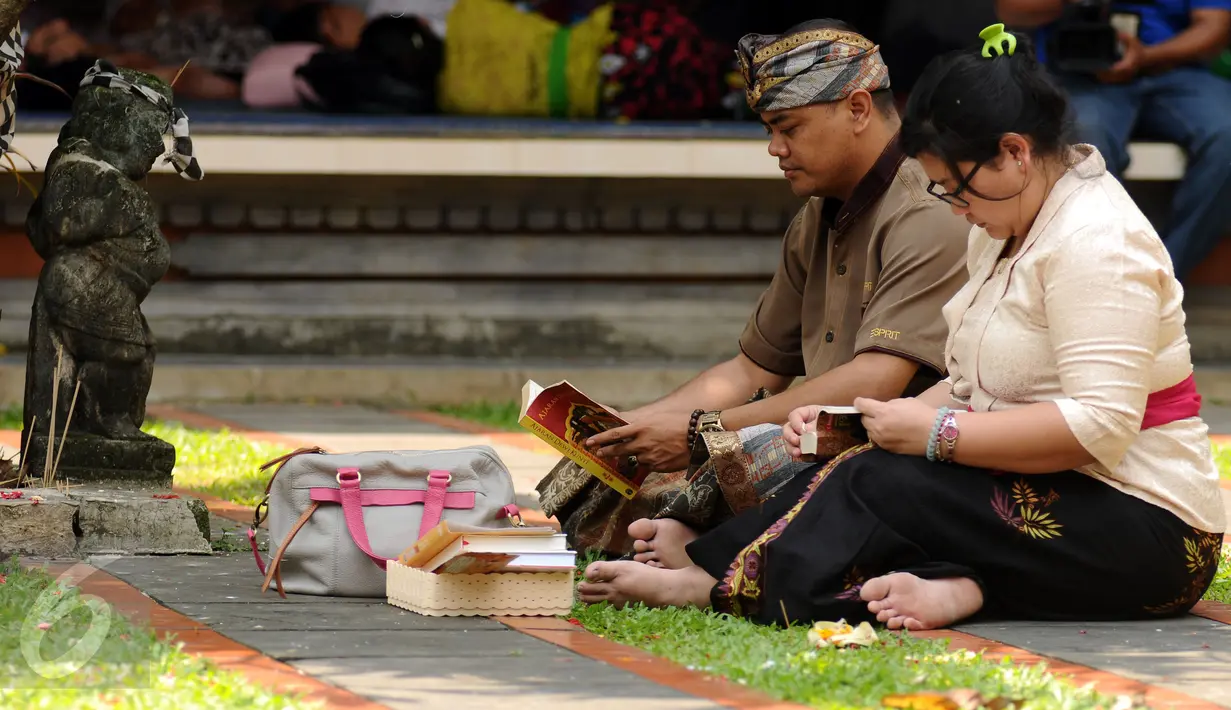 Umat Hindu membaca buku saat perayaan Nyepi di Pura Aditya Jaya, Rawamangun, Jakarta, Selasa (28/3). Pura Aditya Jaya menjadi tempat perayaan Nyepi umat Hindu di Jakarta (Liputan6.com/Helmi Fithriansyah)