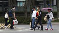 Warga memakai masker untuk melindungi diri dari penyebaran COVID-19 di Taipei, Taiwan, Sabtu (15/5/2021). Taiwan yang telah berhasil membuat iri dalam menahan COVID-19 memberlakukan pembatasan baru di ibu kotanya saat memerangi wabah terburuk sejak pandemi dimulai. (AP Photo/Chiang Ying-ying)