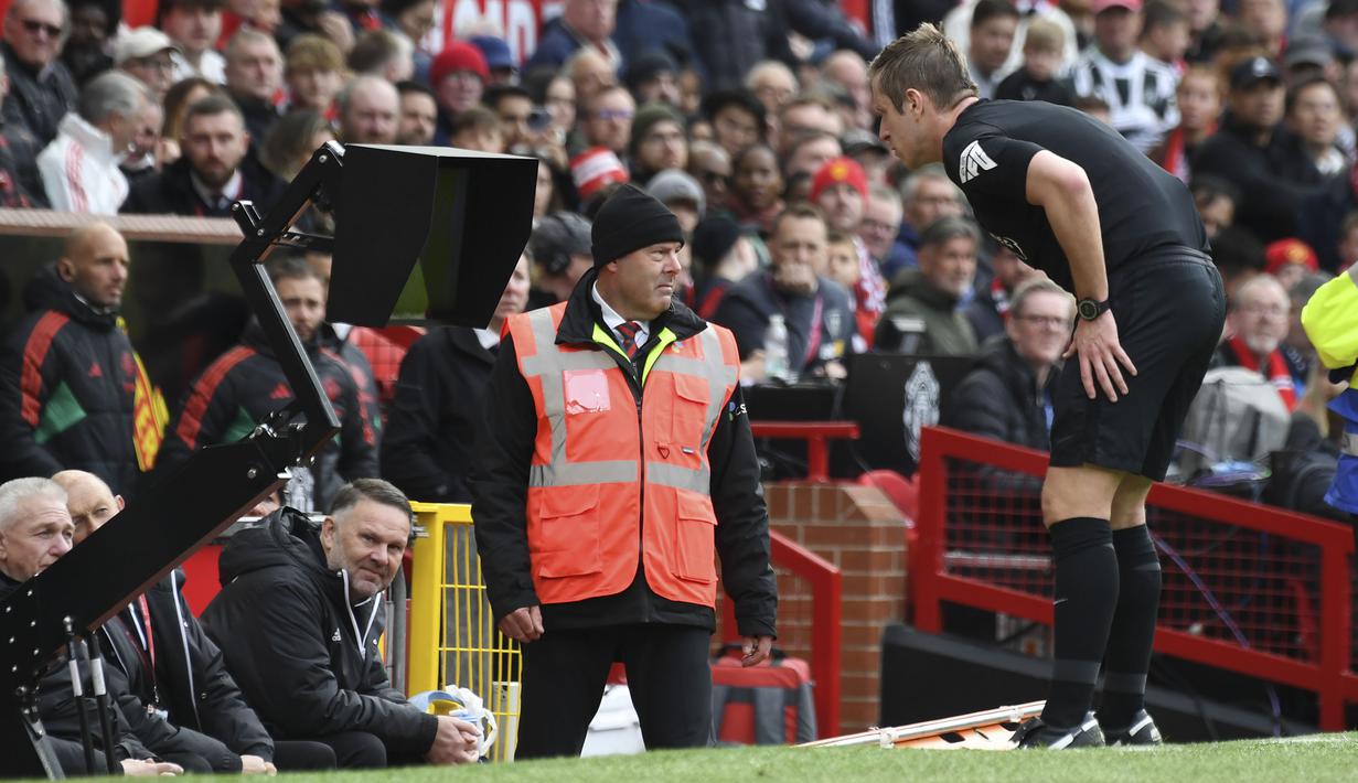 Wasit John Brooks memeriksa rekaman VAR atas pelanggaran kiper Manchester United, Andre Onana terhadap striker Burnley, Zeki Amdouni sebelum menghadiahkan tendangan penalti pada laga pekan ke-35 Premier League 2023/2024 di Old Trafford Stadium, Manchester, Sabtu (27/4/2024). (AP Photo/Rui Vieira)