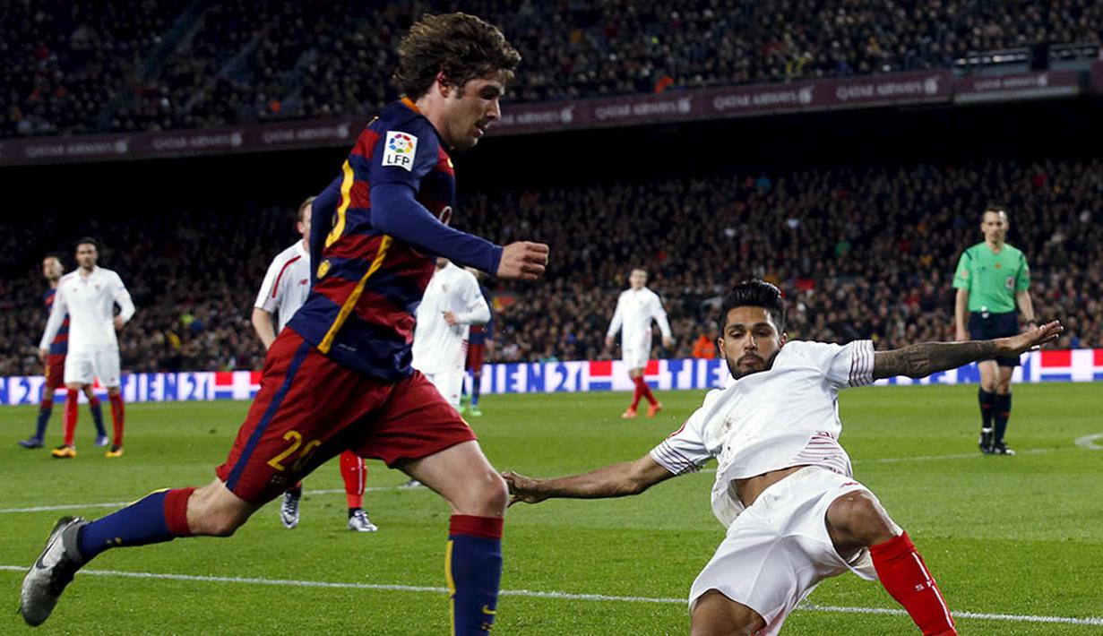 Gelandang Barcelona, Sergi Roberto, berusaha melewati tekel  bek sayap Sevilla, Benoit Tremoulinas. Kemenangan ini membuat Barca kian kokoh di puncak klasemen La Liga Spanyol. (Reuters/Albert Gea)