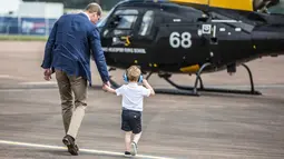Pangeran George berjalan bersama ayahnya, Pangeran William saat mengunjungi Royal International Air Tattoo di RAF Fairford di Gloucestershire, Inggris, (8/7). (REUTERS/Richard Pohle)