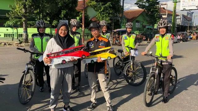 Penggemar miniatur bus Banjarnegara berfoto dengan polwan. (Foto: Liputan6.com/Zaki untuk Muhamad Ridlo)