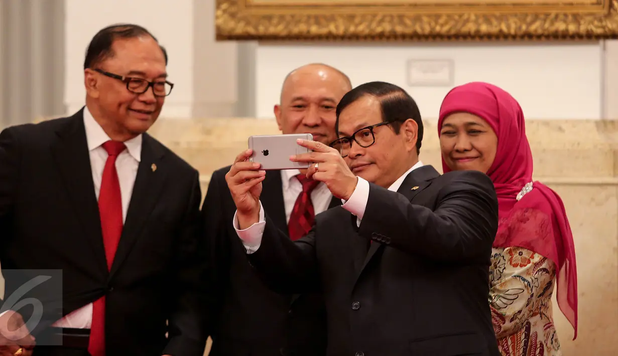 Seskab Pramono Anung  (kanan) berselfi dengan Kepala Staf Presiden Teten Masduki  (tengah) sebelum acara pelantikan dirinya yang dipimpin Presiden Jokowi di Istana Negara, Jakarta, Selasa (2/9). (Liputan6.com/Faizal Fanani)