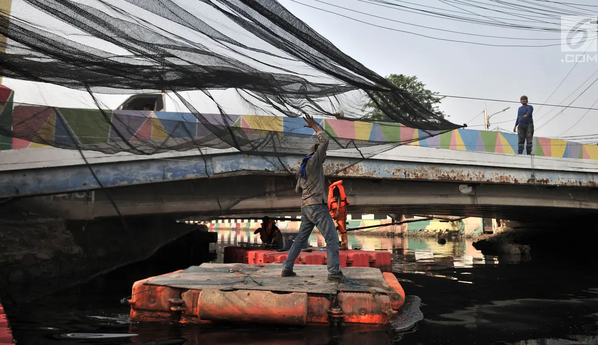Petugas Dinas Sumber Daya Air DKI Jakarta memasang sling sebelum pemasangan waring di Kali Sentiong atau Kali Item, Tanjung Priok, Selasa (31/7). Pemprov DKI Jakarta menambah pemasangan waring dari Jembatan Marto. (Merdeka.com/Iqbal S Nugroho)