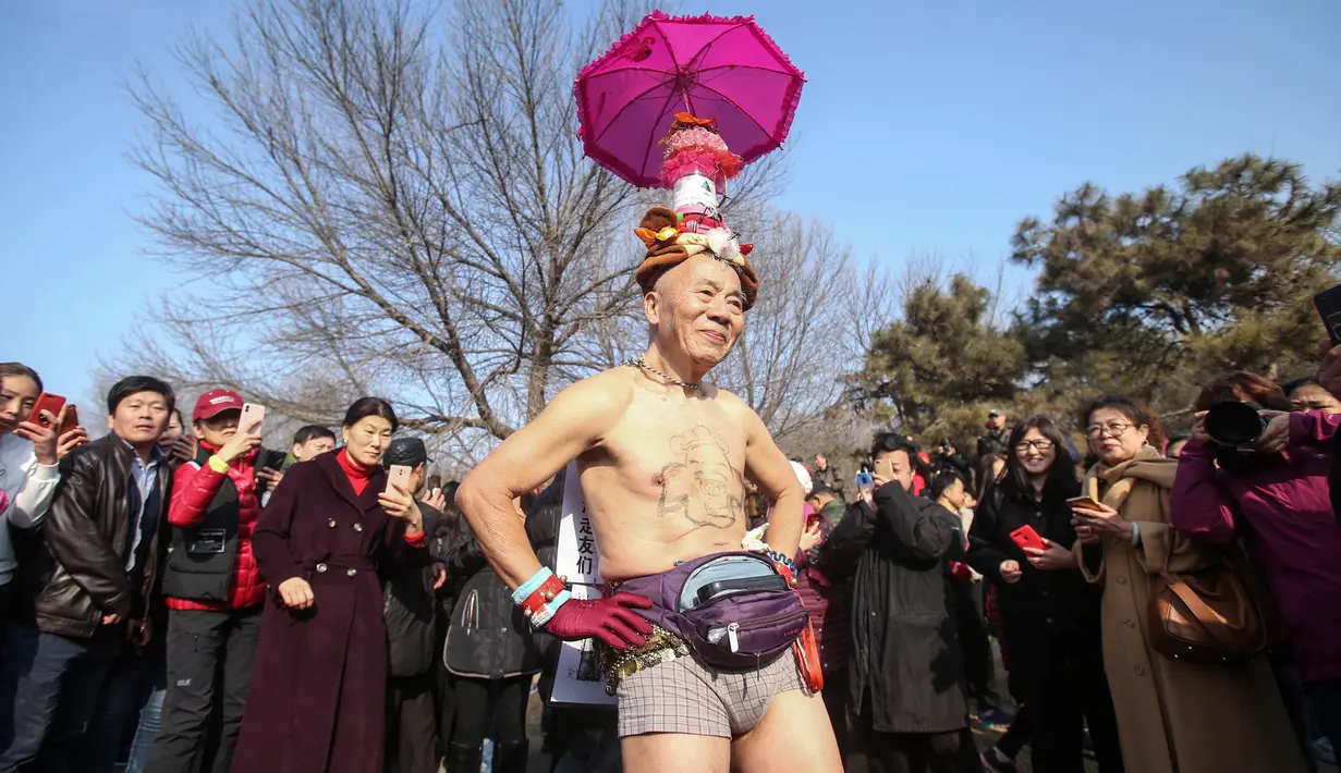 Seorang kakek berpose dalam lomba lari tahunan Undie Run di Olympic Forest Park, Beijing pada 24 Februari 2019. Uniknya para peserta diwajibkan berlari sambil mengenakan kostum unik atau pakaian dalam saja. (Photo by STR / AFP)