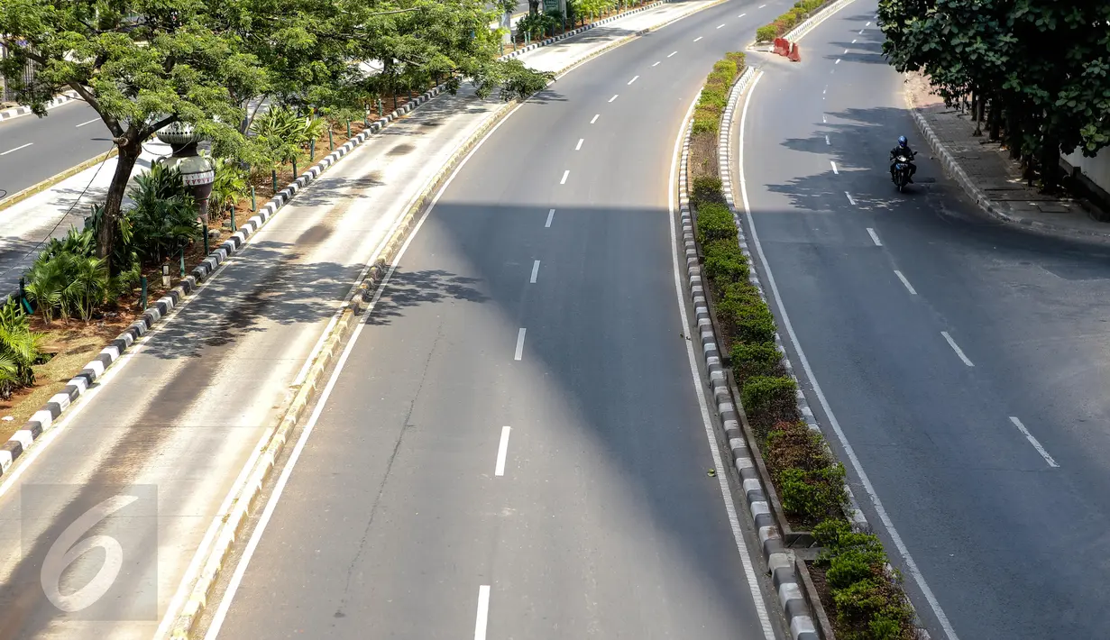 Pengendara motor melintasi jalan protokol di kawasan Kuningan, Jakarta, Kamis (16/7/2015). H-1 jelang Lebaran, situasi Ibukota Jakarta sudah sepi ditinggal warganya yang mudik ke kampung halaman. (Liputan6.com/Faizal Fanani)