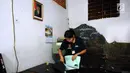 Petugas mengecek dokumen di rumah terduga penampung TKI Ilegal di Jalan Percetakan Negara X, Jakarta, Rabu (31/5). Bersama satu tersangka, petugas Dirtipidum Mabes Polri melakukan pencarian barang bukti baru. (Liputan6.com/Helmi Fithriansyah)