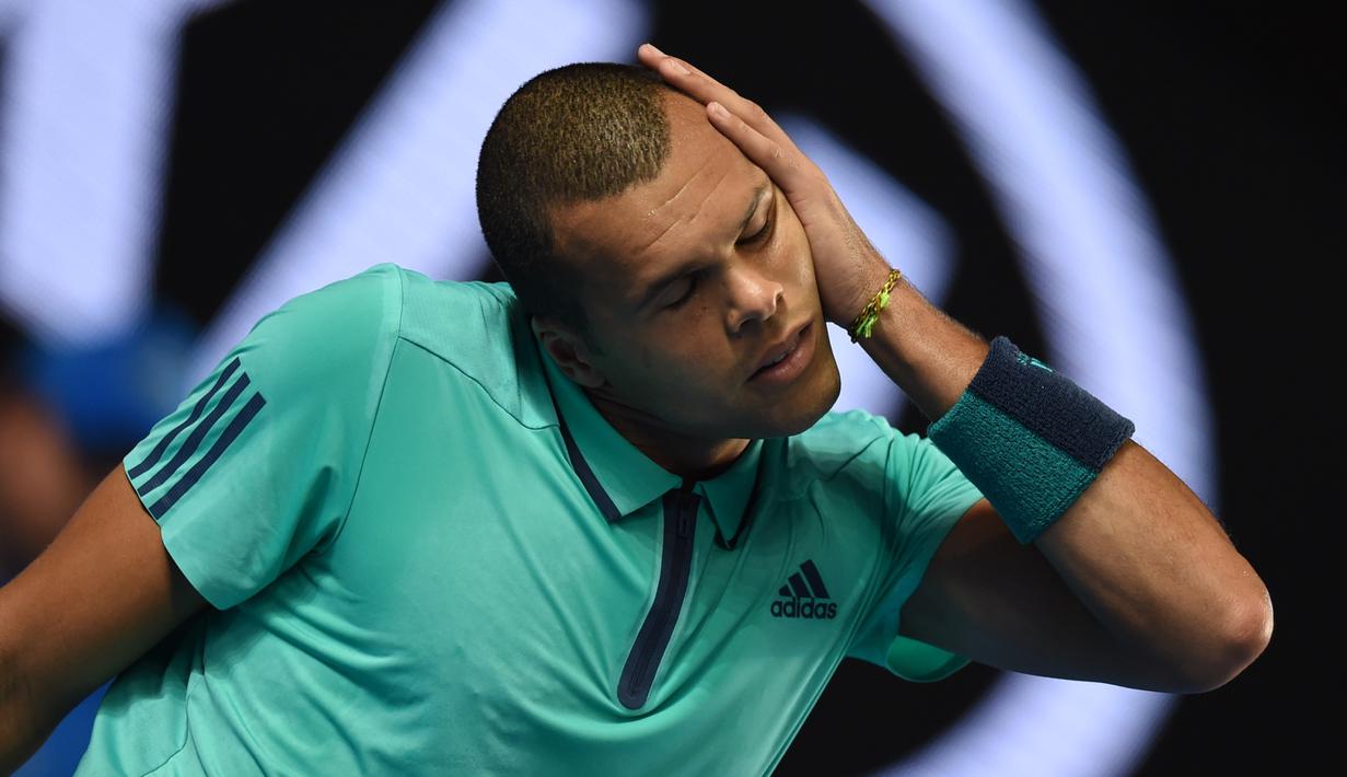 Ekspresi petenis putra Prancis, France's Jo-Wilfried Tsonga, saat peregangan otot jelang melawan petenis Jepang, Kei Nishikori, di turnamen tenis Australia Terbuka 2016 di Melbourne Park, Australia, (24/1/2016). (AFP/Greg Wood)