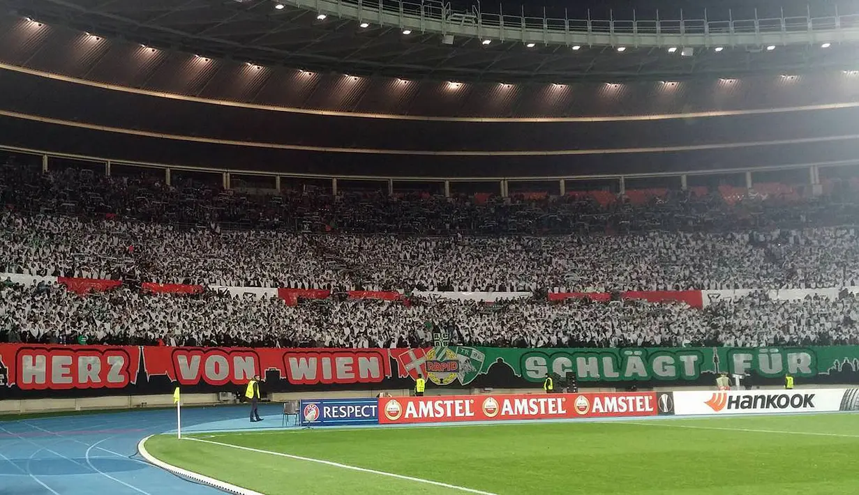 Suporter Rapid memberikan atraksi koreografi menarik pada laga lanjutan Grup E Liga Europa. Jumat (23/10/2015) dini hari WIB.(Bola.com/Reza Khomaini)