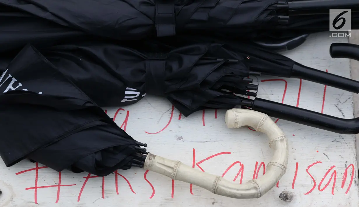 Payung aktivis peserta aksi Kamisan tergeletak di kawasan Silang Barat Laut Monas, Jakarta, Kamis (24/1). Dalam aksi Kamisan ke-571, JSKK mengeluarkan surat terbuka meminta NKRI jangan dijadikan negara impunitas. (Liputan6.com/Helmi Fithriansyah)