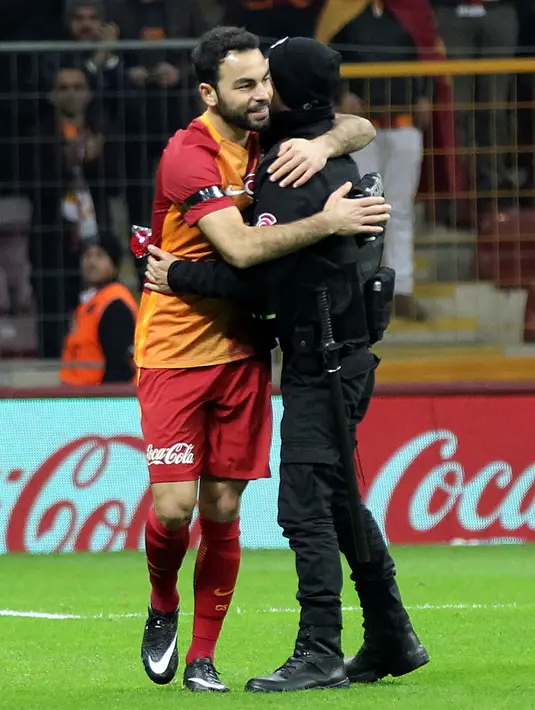 Pemain Galatasaray, Yasin Oztekin memeluk petugas polisi setelah mencetak gol saat melawan Gaziantepspor dalam Liga Super Turki di Istanbul, Minggu (11/12). Itu dilakukan Oztekin sebagai ungkapan duka cita atas tragedi ledakan bom Besiktas (AFP PHOTO/STR)