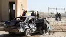 Sebuah mobil hancur akibat bom truk yang meledak di sekolah polisi di kota Zliten, wilayah barat Libya, Kamis (7/1). Belum ada yang mengaku bertanggung jawab terkait serangan bom yang menewaskan sedikitnya 50 orang tersebut. (AFP PHOTO/MAHMUD Turkia)