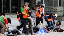 Pegawai kantor distrik mengenakan rompi visibilitas tinggi saat mereka membantu menolong korban selama simulasi latihan anti-teror, di Seoul, Korea Selatan pada tanggal 20 Agustus 2024. (ANTHONY WALLACE/AFP)