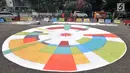 Petugas Prasarana dan Sarana Umum (PPSU) Kelurahan Pegangsaan saat menyelesaikan pembuatan logo Asian Games 2018 di Jalan Penataran atau Simpang Tugu Proklamasi, Jakarta, Rabu (25/7).  (Merdeka.com/Iqbal S. Nugroho)