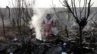Tim penyelamat mencari korban pesawat Boeing 737 milik maskapai Ukraina yang jatuh di Shahedshahr, Iran, Rabu (8/1/2020). Pesawat Ukraine International Airlines tersebut dilaporkan mengangkut 176 orang termasuk kru. (AP Photo/Ebrahim Noroozi)
