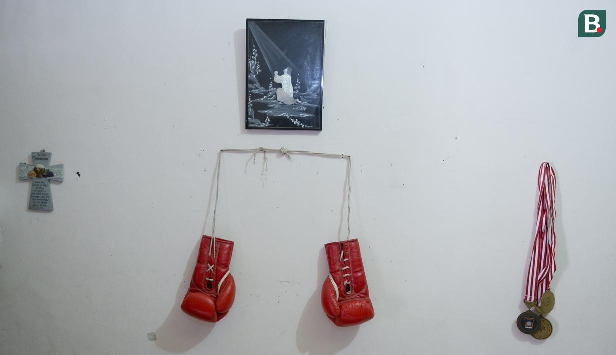 Sarung tinju dan medali legenda tinju Indonesia, Ellyas Pical, di Kawasan Bintaro, Jumat (13/7/2018). Ellyas Pical adalah petinju Indonesia pertama yang berhasil menjadi juara dunia. (Bola.com/M Iqbal Ichsan)