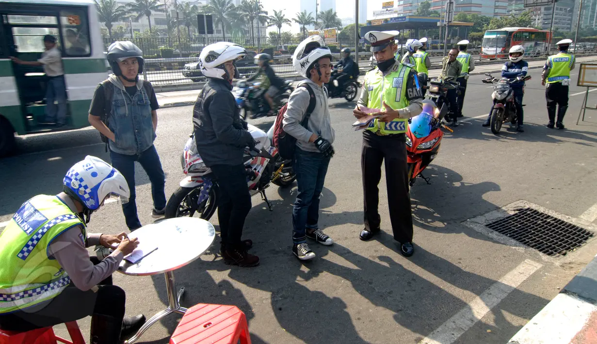 Sejumlah pengendara motor terkena tilang di sepanjang Jalan Jendral Sudirman, Jakarta, Sabtu (30/5/2015). Polisi menggelar razia patuh jaya untuk menertibkan para pengendara yang melanggar lalu lintas, mulai 27 Mei-9 Juni. (Liputan6.com/Yoppy Renato)